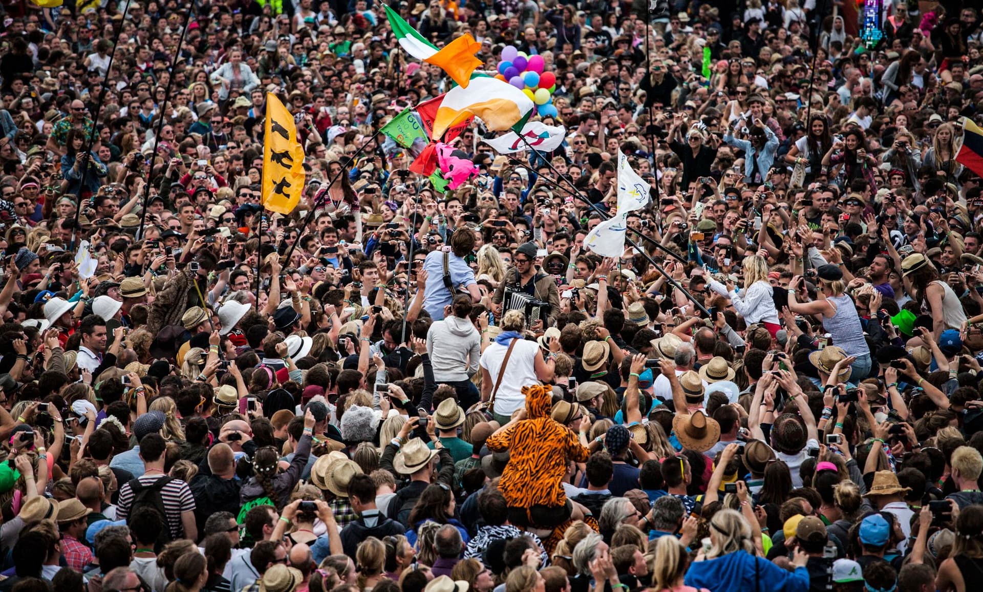 Stort publikum med flagg foran en utendørs festivalscene